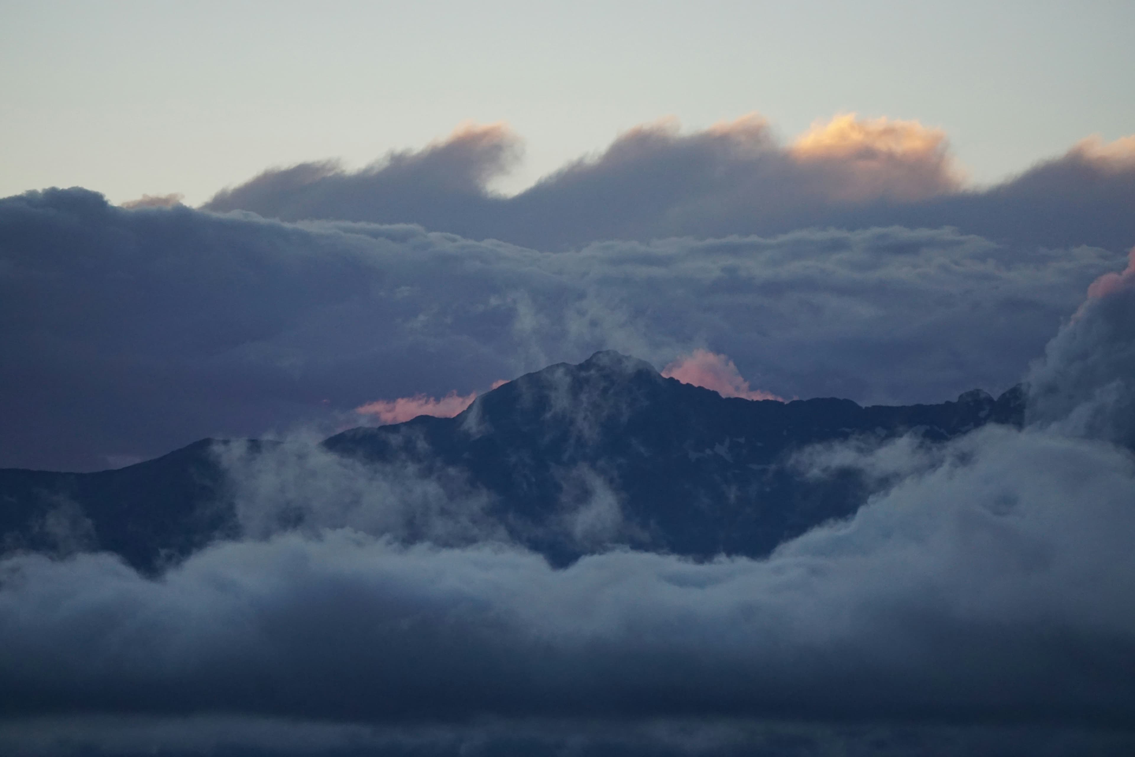 Cloudy sunrise over snowy alpine ridge